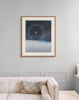 Framed art print of "A Cold Beauty, Lunar Halo" by Nicholas Jones, shown in an elegant, minimalist room with a classic sofa and a window seat. Displayed here in size extra-large.