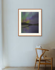 Framed art print of "Aurora Reflected", displayed in a minimalist space lit by soft filtered light, with a wooden chair nearby. Shown here in the size extra-large.