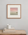 Framed above a wooden bench with a book and cup, “Evening Stillness” invites a quiet pause at the close of day.
