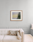 Framed art print of 'Evening Rainbow, Lake Nellim, Finland", shown in an elegant, minimalist room with a classic sofa and a window seat. Displayed here in the size large.