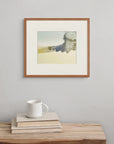 Framed above a wooden bench with a book and cup, “Moorland Veil” is a screen print that evokes the quiet mystery of upland moorland.