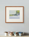Framed fine art print of “Moorland Veil", displayed above a simple rustic wooden bench. Two linen-covered books and a white mug rest quietly on the bench, adding to the calm atmosphere.