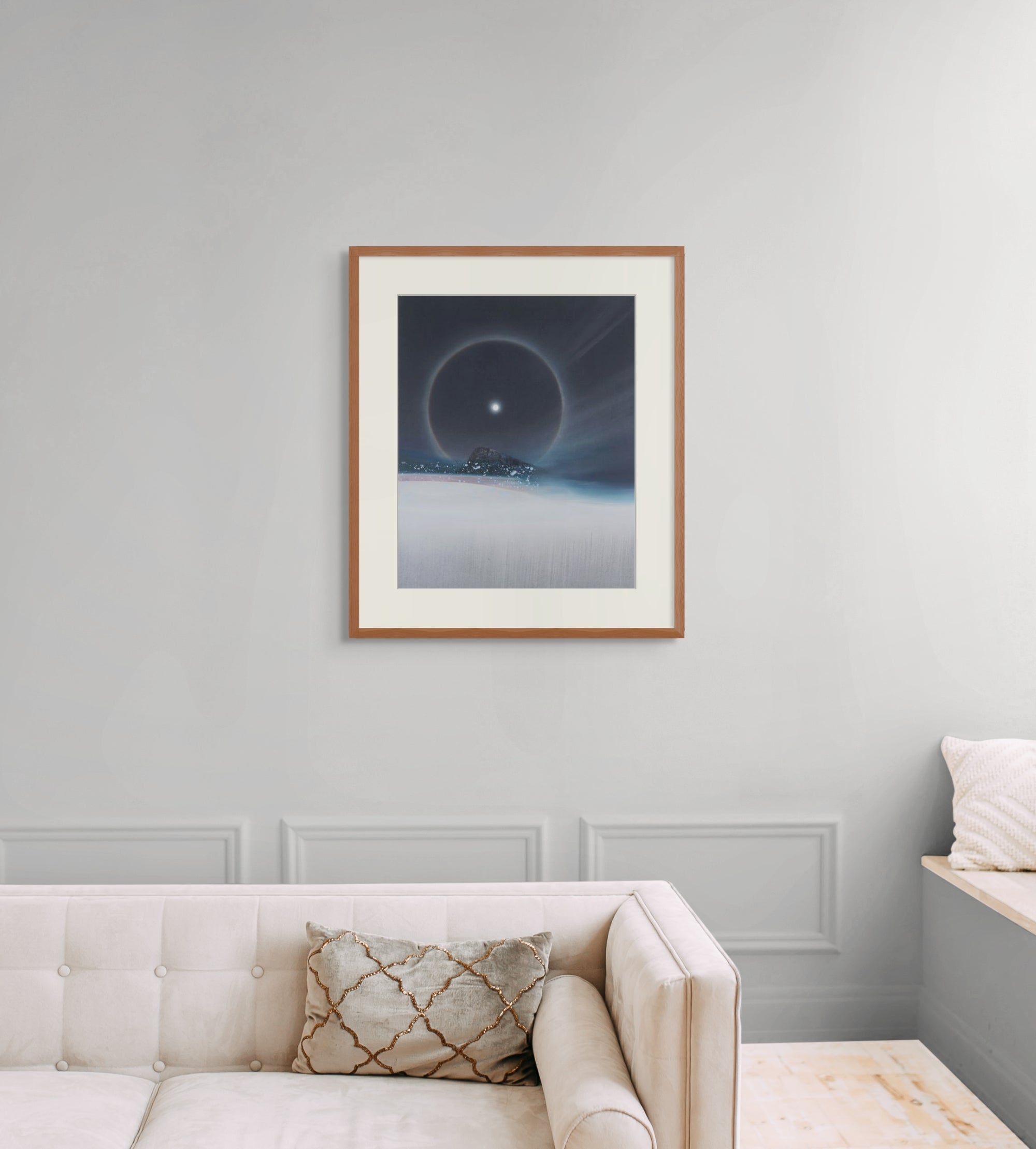 Framed art print of "A Cold Beauty, Lunar Halo" by Nicholas Jones, shown in an elegant, minimalist room with a classic sofa and a window seat. Displayed here in size large.