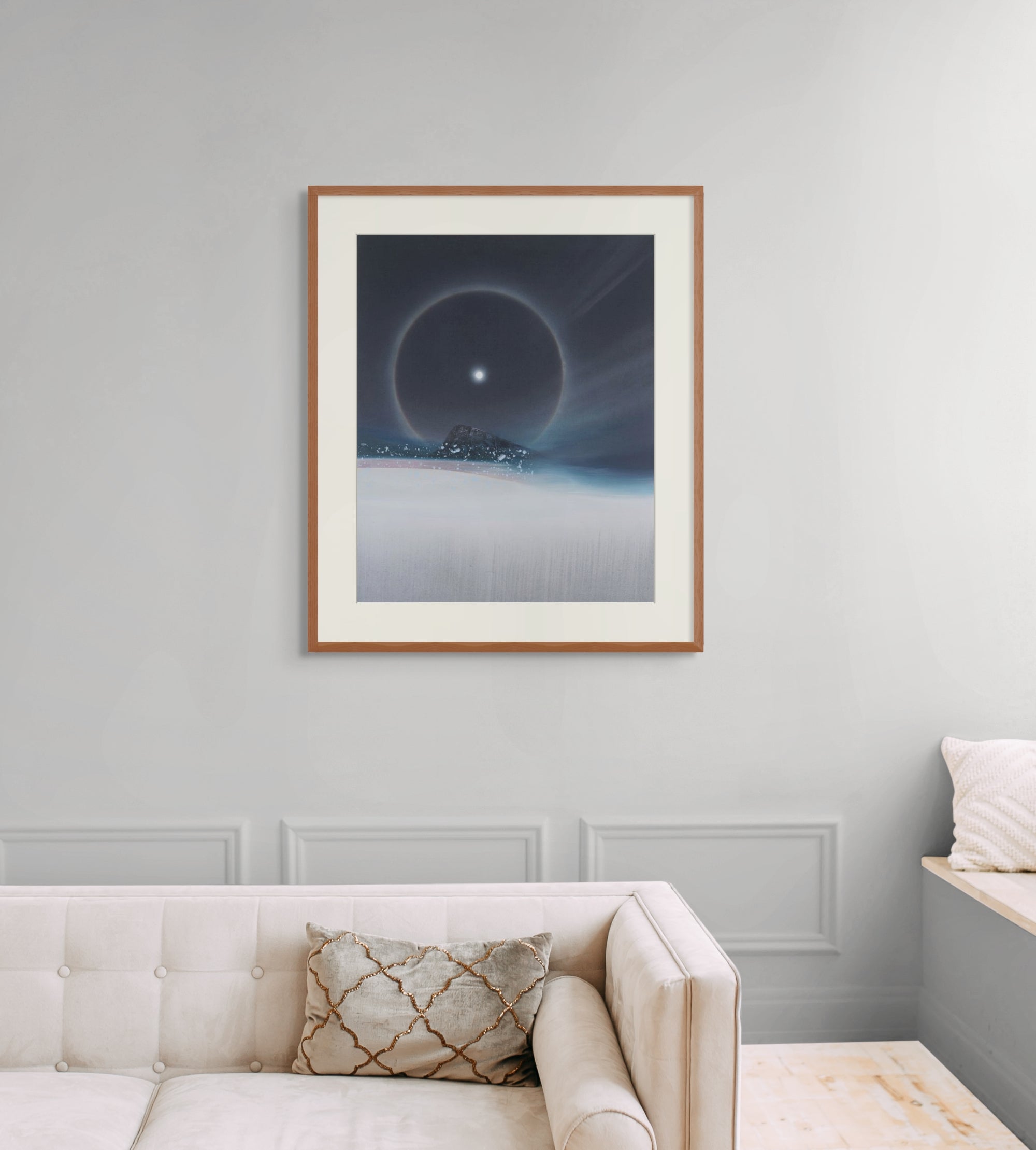 Framed art print of "A Cold Beauty, Lunar Halo" by Nicholas Jones, shown in an elegant, minimalist room with a classic sofa and a window seat. Displayed here in size extra-large.